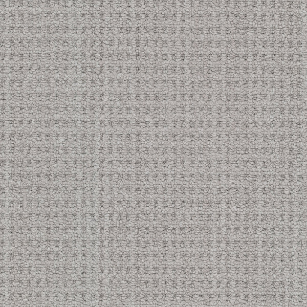 Close-up of Winslow Berber Carpet in light gray, highlighting its textured woven surface with a subtle grid pattern and slightly raised threads that create natural shading variations.