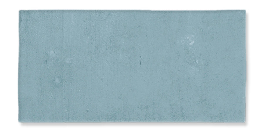 A rectangular, light blue bath mat with a soft, plush texture is displayed on a white background, inspired by the calming hues of the Fez 2.5x5 Subway Tile.