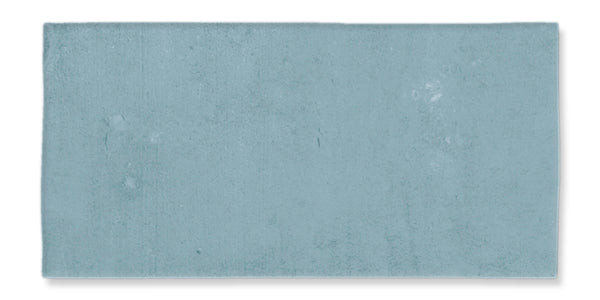 A rectangular, light blue bath mat with a soft, plush texture is displayed on a white background, inspired by the calming hues of the Fez 2.5x5 Subway Tile.