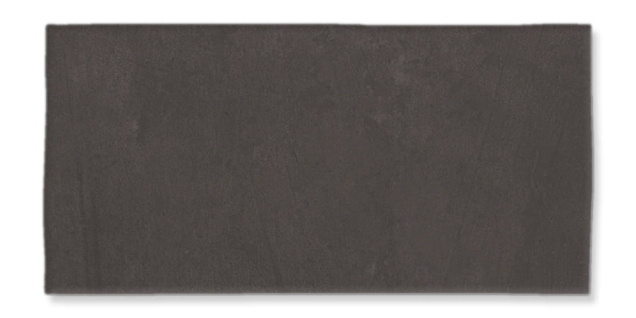 The Fez 2.5x5 Subway Tile is a rectangular, dark gray glazed ceramic tile with a smooth, matte surface and subtle texture, shown against a white background.
