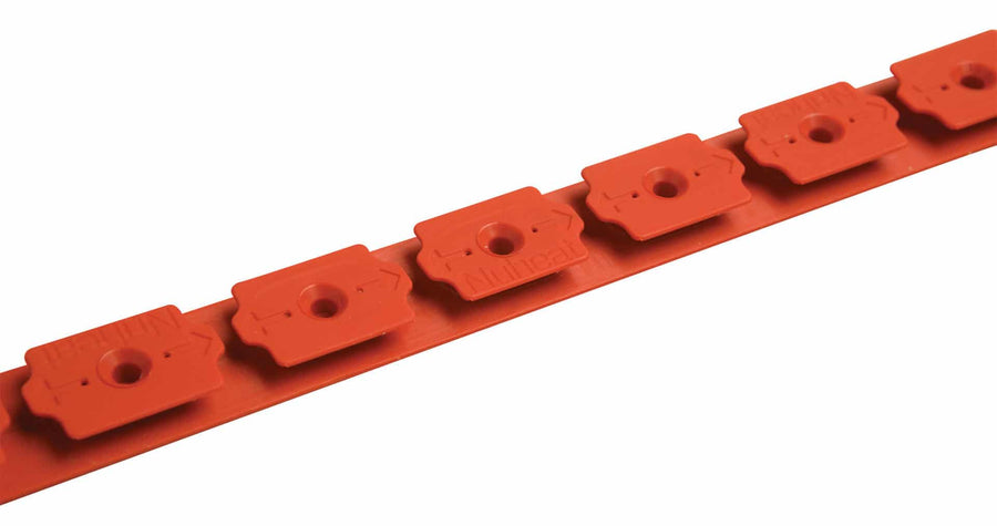 A close-up of the nVent Nuheat Cable Guide, a red plastic strip with evenly spaced rectangular clips, each with a circular hole—perfect for securing Nuheat floor heating cable and providing flexible installation on site.