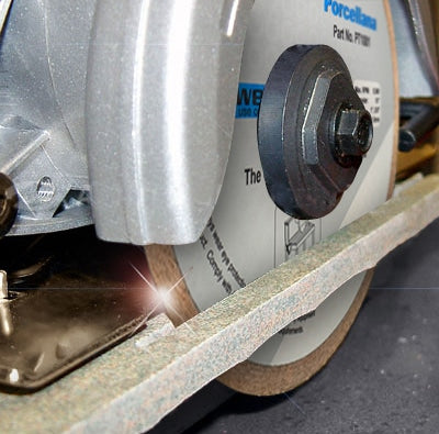 Close-up of the Alpha Porcellana Wet Blade for Porcelain slicing through a tile with wet cutting, showing visible sparks at the contact point.