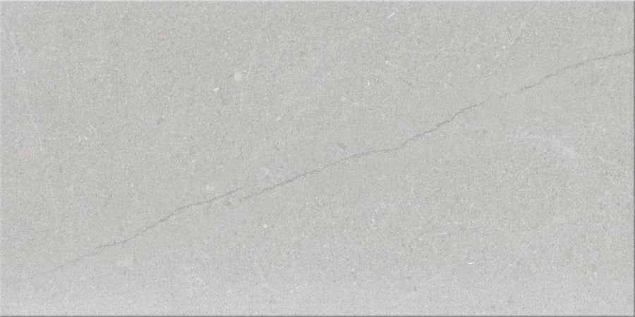 The Sandwaves 24x48 Porcelain Tile features a light gray tone with a subtle diagonal crack, minimal texture, and fine speckles—an ideal choice for contemporary decor.
