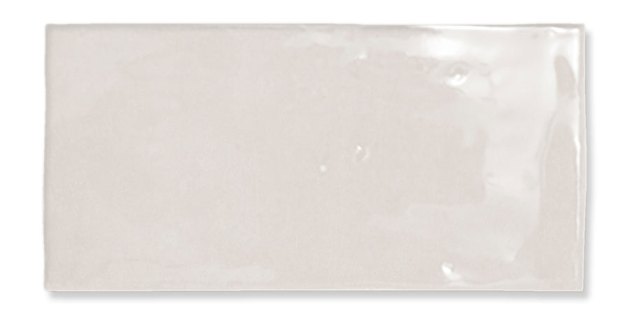 Fez 2.5x5 Subway Tile: a rectangular, light beige glazed ceramic tile with a glossy, smooth yet slightly uneven surface and subtle reflections.