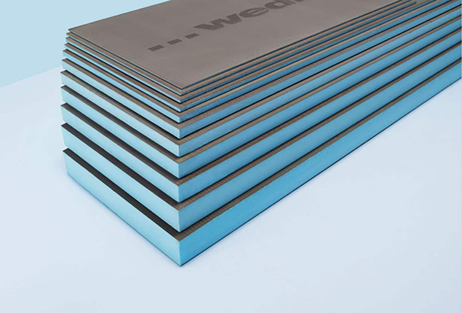 A stack of rectangular Wedi Boards, blue and waterproof with dark gray surfaces, is neatly aligned on a light blue background.