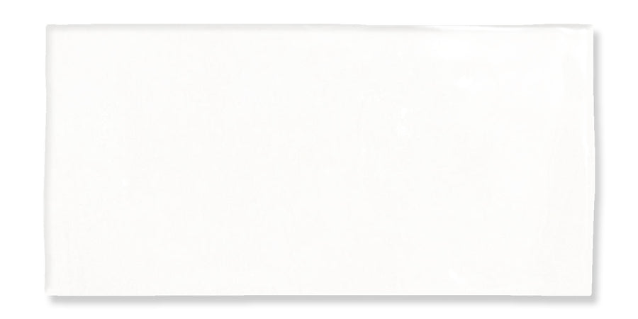 A Fez 2.5x5 Subway Tile, rectangular and white, lies on a white background with a subtle shadow to the right, evoking the look of smooth glazed ceramic.